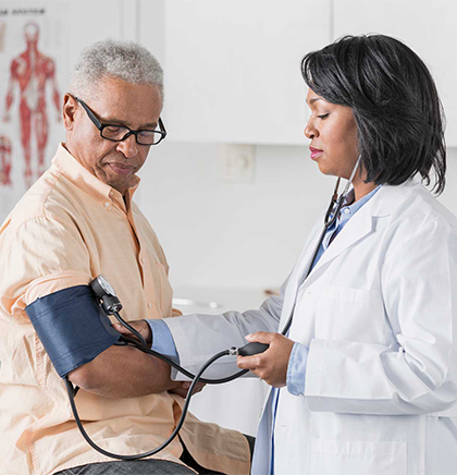 A hand holding a blood pressure cuff over an arm.