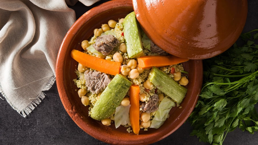 Agneau cuit et couscous avec légumes joliment disposés dans un plat prêt à servir. Agneau cuit et couscous avec légumes joliment disposés dans un plat prêt à servir.