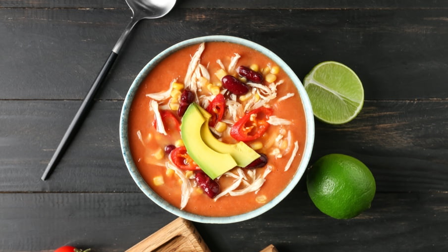 Soupe enchilada au poulet cuite dans un bol avec citrons verts. Soupe enchilada au poulet cuite dans un bol avec citrons verts.