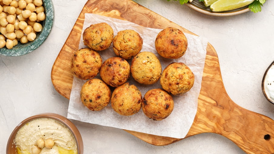 Burgers de falafel avec sauce sésame crémeuse sur une planche à découper. Burgers de falafel avec sauce sésame crémeuse sur une planche à découper.