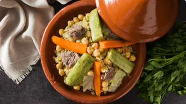 Cooked lamb and couscous with beautifully arranged vegetables in a dish ready to be served. Cooked lamb and couscous with beautifully arranged vegetables in a dish ready to be served.