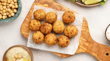 Falafel burgers with chickpeas and creamy sauce on a cutting board. Falafel burgers with chickpeas and creamy sauce on a cutting board.