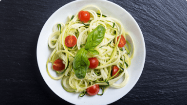 Zucchini pasta with tomato and basil in a bowl. Zucchini pasta with tomato and basil in a bowl.