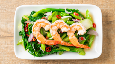 Cooked shrimp on top of sautéed gai lan. Cooked shrimp on top of sautéed gai lan.
