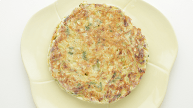 Crispy, Japanese-inspired pancake on a plate. Crispy, Japanese-inspired pancake on a plate.