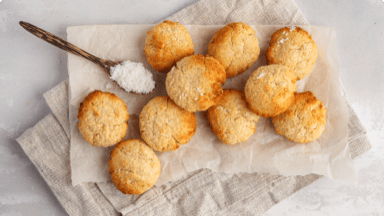 Browned orange and coconut cookies cooling on parchment paper. Browned orange and coconut cookies cooling on parchment paper.