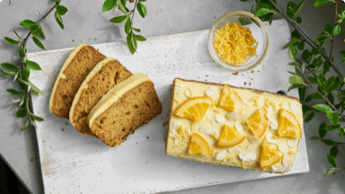 Sliced almond orange loaf with icing on a cutting board. Sliced almond orange loaf with icing on a cutting board.