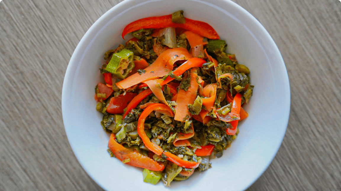 Colourful medley of cooked callaloo, okra and peppers in a bowl. Colourful medley of cooked callaloo, okra and peppers in a bowl.