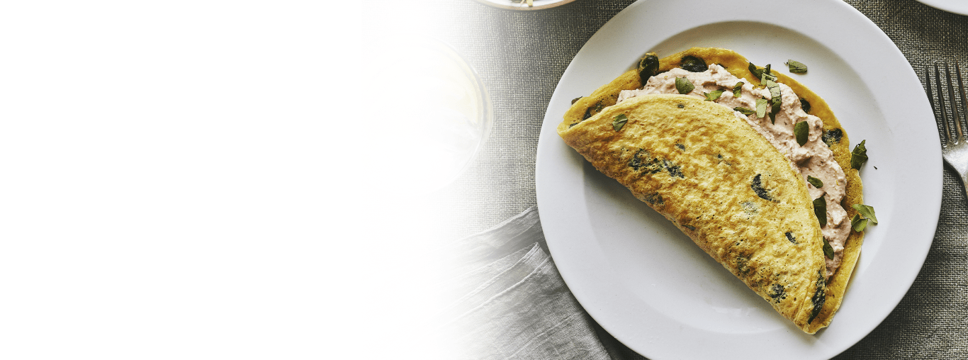 Spinach and sundried tomato stuffed crepe omelette ready to be eaten.