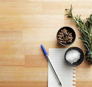Pen and paper next to herbs and seasoning