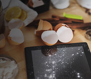 iPad recouvert en partie de farine à côté d'ingrédients pour cuisiner